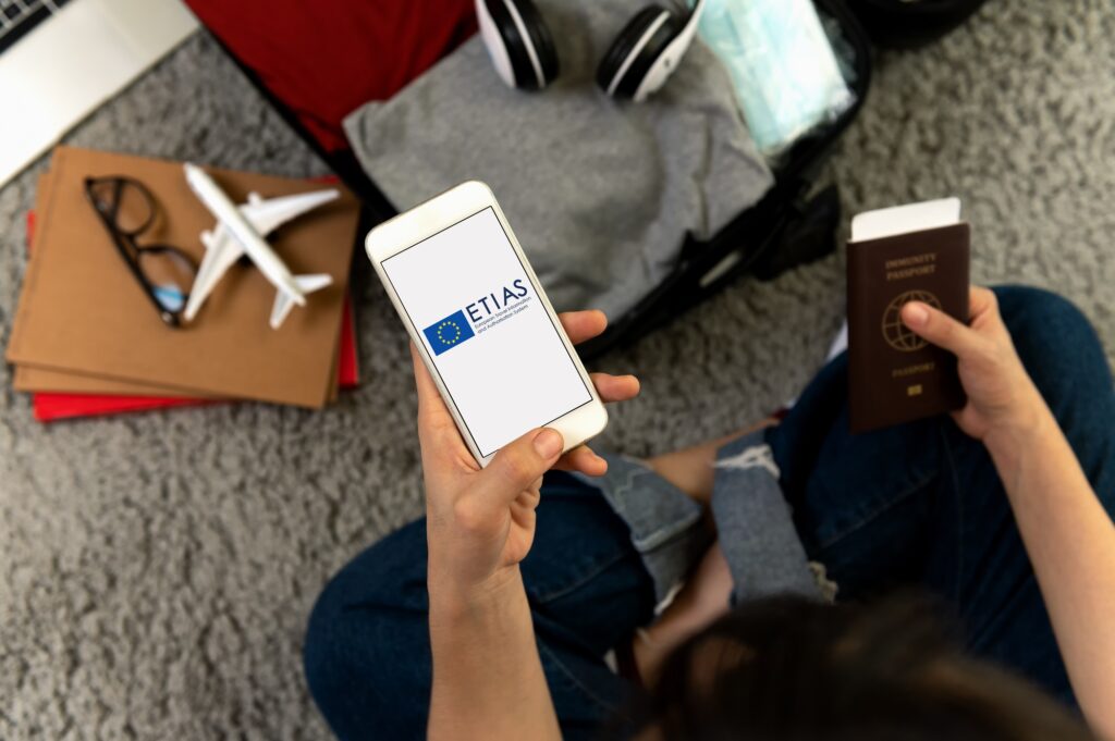 Traveler using laptop to complete the ETIAS 2025 online application for visa-free entry to Europe under the new travel authorization system